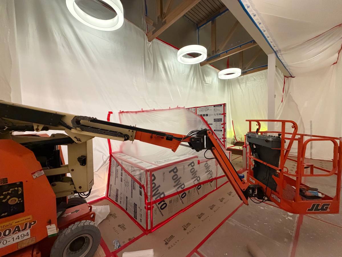Boom lift and containment inside a commercial building during interior painting
